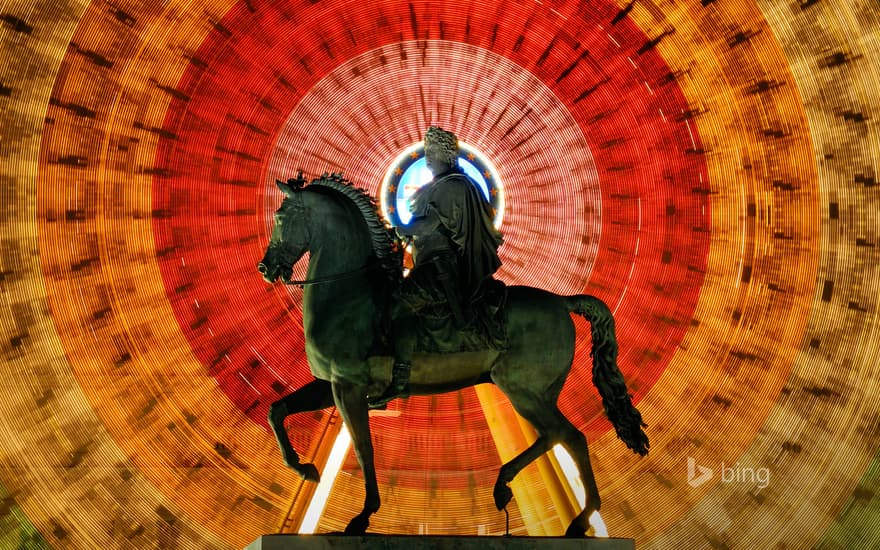 Louis XIV statue and spinning Ferris wheel at Place Bellecour in Lyon, France